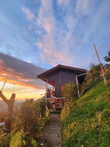 a house on a hill with a sunset in the background at Kiau View Cabin in Kota Belud +12 photos