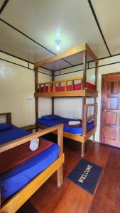 a room with three bunk beds and a door at Kiau View Cabin in Kota Belud