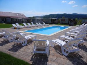 a row of lounge chairs next to a swimming pool at Nemeth Camping Spa & Pool Access in Sovata
