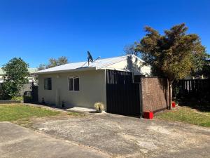 una casa bianca con una recinzione davanti di The Sandy Jandal a Karikari Peninsula
