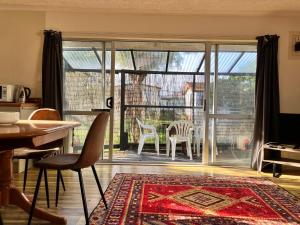 un soggiorno con una grande porta scorrevole in vetro di The Sandy Jandal a Karikari Peninsula