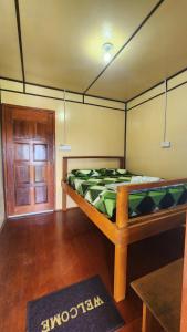 a bedroom with a bed and a wooden door at Kiau View Cabin in Kota Belud