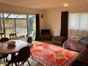 a living room with a couch and a table with a rug at 1 min walk to beach, tidy & comfortable in Karikari Peninsula