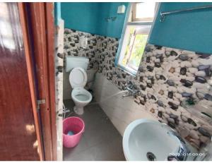 a bathroom with a toilet and a sink and a window at Ngima woizer Homestay,Tawang in Tawang