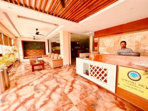a man standing behind a counter in a lobby at Hotel Amritsar View with Swimming Pool - Best Selling Hotel in Amritsar near Golden Temple in Amritsar