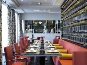 una sala da pranzo con un lungo tavolo e sedie rosse di Le Royal Hotel Lyon - MGallery Collection a Lione