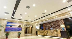 a lobby with a large painting on the wall at Lavande Hotel Tianjin Binhia Yujiabao Finance Center Branch in Binhai