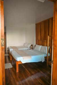 two beds in a room with wooden floors at Seaside Beach Hostel in San Vicente