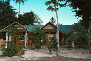 a house with palm trees in front of it at Seaside Beach Hostel in San Vicente
