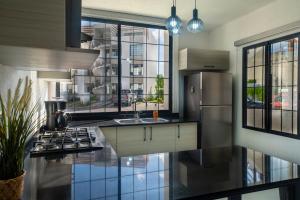 a kitchen with a stainless steel refrigerator and a sink at Departamento en condominio con alberca excelente ubicación in Manzanillo