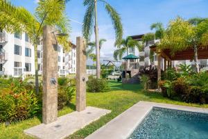 a yard with a swimming pool and palm trees at Departamento en condominio con alberca excelente ubicación in Manzanillo