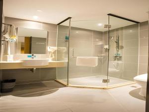 a bathroom with a glass shower and a sink at City Comfort Inn Hotel Nanning Nanhu Park Macun Metro Station in Nanning +168 photos