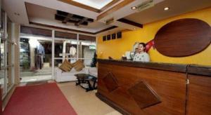 a woman standing at a bar in a room at De Hotel Veda in Kathmandu