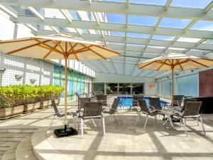 a patio with tables and chairs and umbrellas at Novotel Sao Paulo Center Norte in Sao Paulo