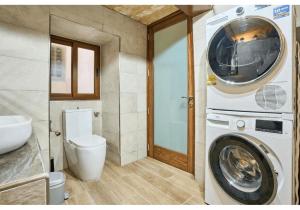 Un baño con lavadora y un inodoro. en Birgu's central traditional apartment, en Birgu 21 fotos más