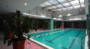 a large swimming pool in a large building at Dalian Bohai Pearl Hotel in Dalian