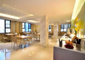 a large room with tables and chairs in a building at City Comfort Inn Kunming Cuihu Hospital of Yunnan University Panjiawan Metro Station in Kunming