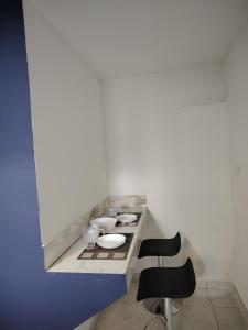 a white room with two chairs and a counter at minidepartamento a unos pasos de la gran pirámide in Cholula +2 photos