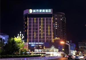a building with a sign on top of it at night at City Comfort Inn Kunming Cuihu Hospital of Yunnan University Panjiawan Metro Station in Kunming
