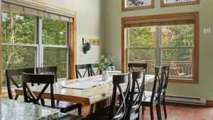 a dining room with a wooden table and chairs at Otter Banks by AvantStay Sleeps 18 Hot Tub Views Game Room in Albrightsville