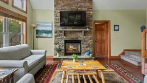 a living room with a couch and a fireplace at Otter Banks by AvantStay Sleeps 18 Hot Tub Views Game Room in Albrightsville