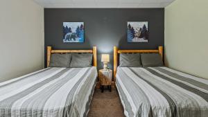 two beds sitting next to each other in a room at Otter Banks by AvantStay Sleeps 18 Hot Tub Views Game Room in Albrightsville