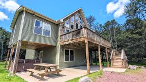 a house with a deck and a picnic table at Otter Banks by AvantStay Sleeps 18 Hot Tub Views Game Room in Albrightsville