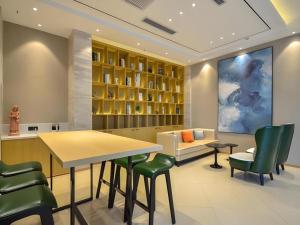 a dining room with a table and green chairs at City Comfort Inn Wuhan Hanyang Street Caidian Square Metro Station in Wuhan