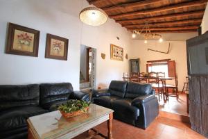 a living room with black leather furniture and a table at Mirador de Santa Ana by SIERRA VIVA in La Corte
