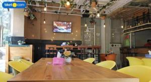 a dining room with a wooden table and yellow chairs at An Hotel Jakarta in Jakarta