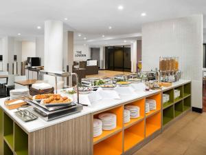 a buffet line with plates and food on display at Mercure Welcome Melbourne in Melbourne