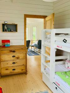 a bedroom with a bunk bed and a dresser at Holiday Home With Fjord Views Near Kyndby in Jægerspris