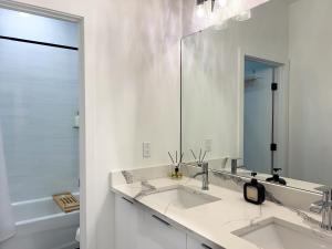 a white bathroom with two sinks and a mirror at NEW! Columbus Cove - Newly Built, Luxurious Home in Heart of Tampa in Tampa +44 photos