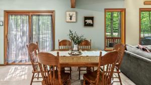 a dining room with a table and chairs at Deer Hollow by AvantStay Big Yard Lake Access in Albrightsville