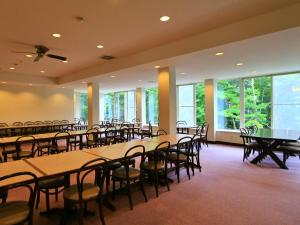 a conference room with tables and chairs and windows at 苗場ビレッヂ in Yuzawa