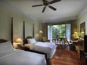 a hotel room with two beds and a balcony at Sofitel Angkor Phokeethra Golf & Spa Resort in Siem Reap