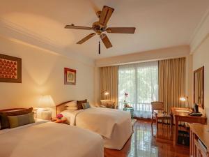 a hotel room with two beds and a ceiling fan at Sofitel Angkor Phokeethra Golf & Spa Resort in Siem Reap +136 photos