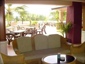 un patio con divano, tavoli e sedie. di Plaloma Cliff Resort a Ko Chang