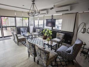 a room with chairs and a table and a tv at Kenari Tower Hotel in Makassar