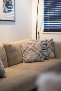 ein Sofa mit zwei Kissen darauf im Wohnzimmer in der Unterkunft 3BR Near Commercial Dr 10 min to Downtown in Vancouver + 57 Fotos