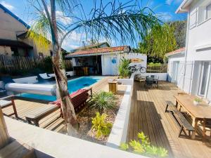 a backyard with a swimming pool and a wooden deck at Villa exceptionnelle à Bayonne avec piscine et parking privée in Bayonne