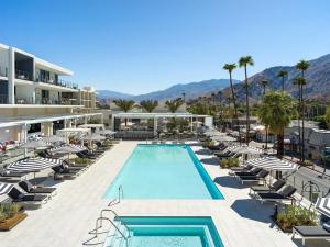 a resort with a swimming pool and lounge chairs at Thompson Palm Springs, By Hyatt in Palm Springs