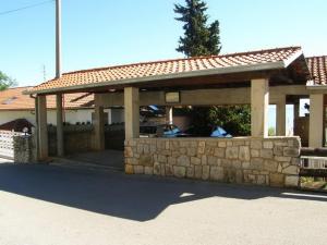 einem Pavillon mit einer Steinmauer vor einem Haus in der Unterkunft Apartments Darinka in Opatija