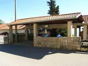 a pavilion with a stone wall in front of a house at Apartments Darinka in Opatija