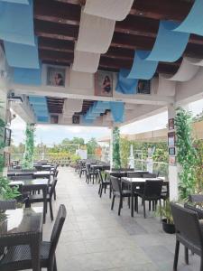 un restaurant avec des tables et des chaises et un grand plafond dans l'établissement CITI HOTEL, à Hilongos 66 autres photos