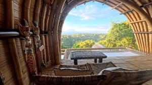 a room with a table and chairs on a balcony at Marilea Bamboo Villas Concept , Private pool, seaview, Adults only in Nusa Penida