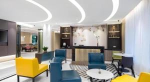 a lobby with blue and yellow chairs and a table at Magnotel Shanghai Maglev Station in Shanghai
