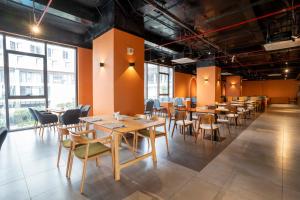 a dining room with tables and chairs and windows at M Continental by Mandala Mui Ne in Phan Thiet