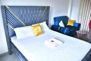 a bedroom with a bed and a blue chair at Crystal Zuri Homes, Kasarani in Nairobi