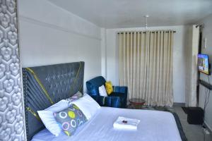 内罗毕Crystal Zuri Homes, Kasarani的一间卧室，有一张床和一把蓝色椅子 更多4张照片